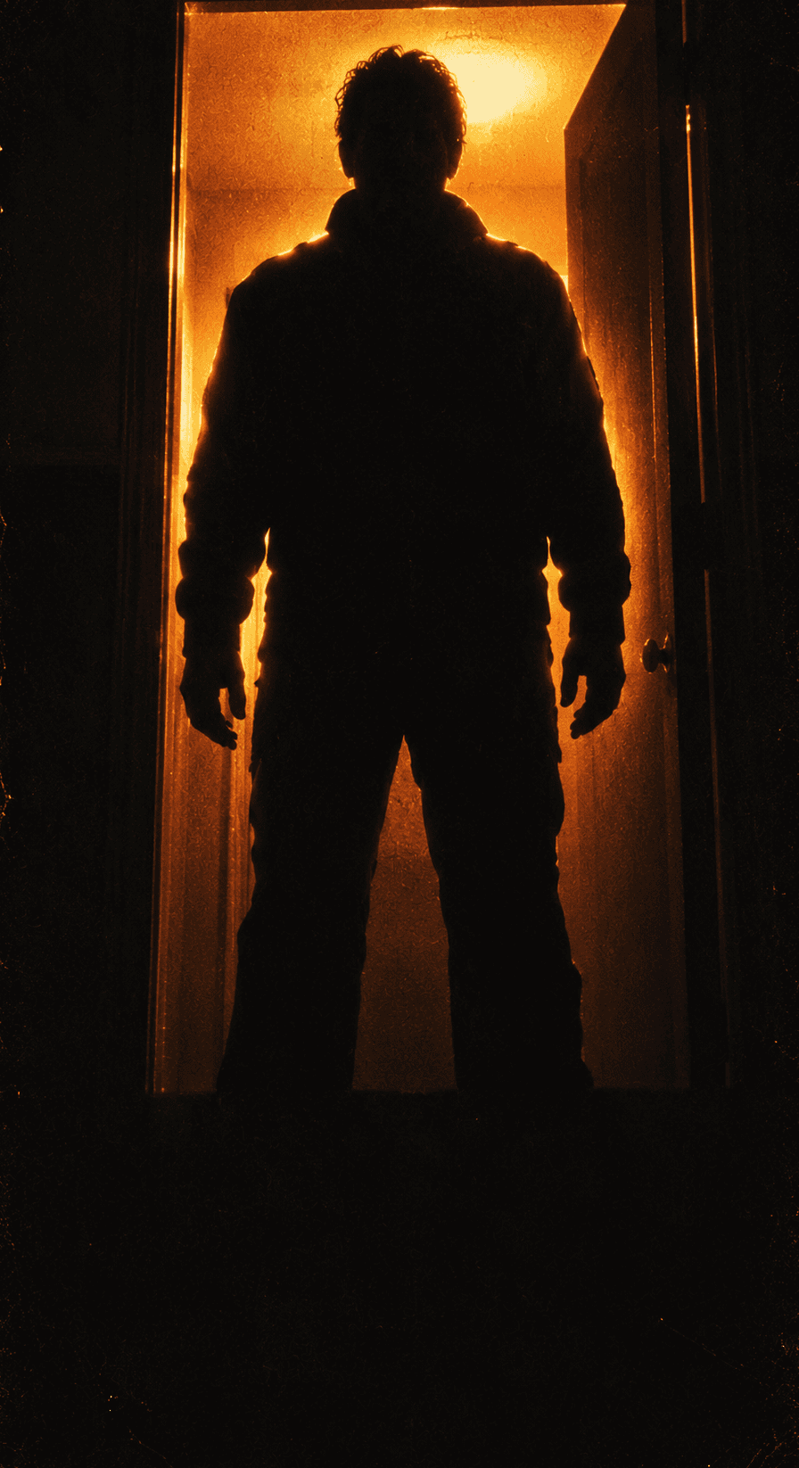 Silhouette of a figure standing in a doorway filled with orange light.